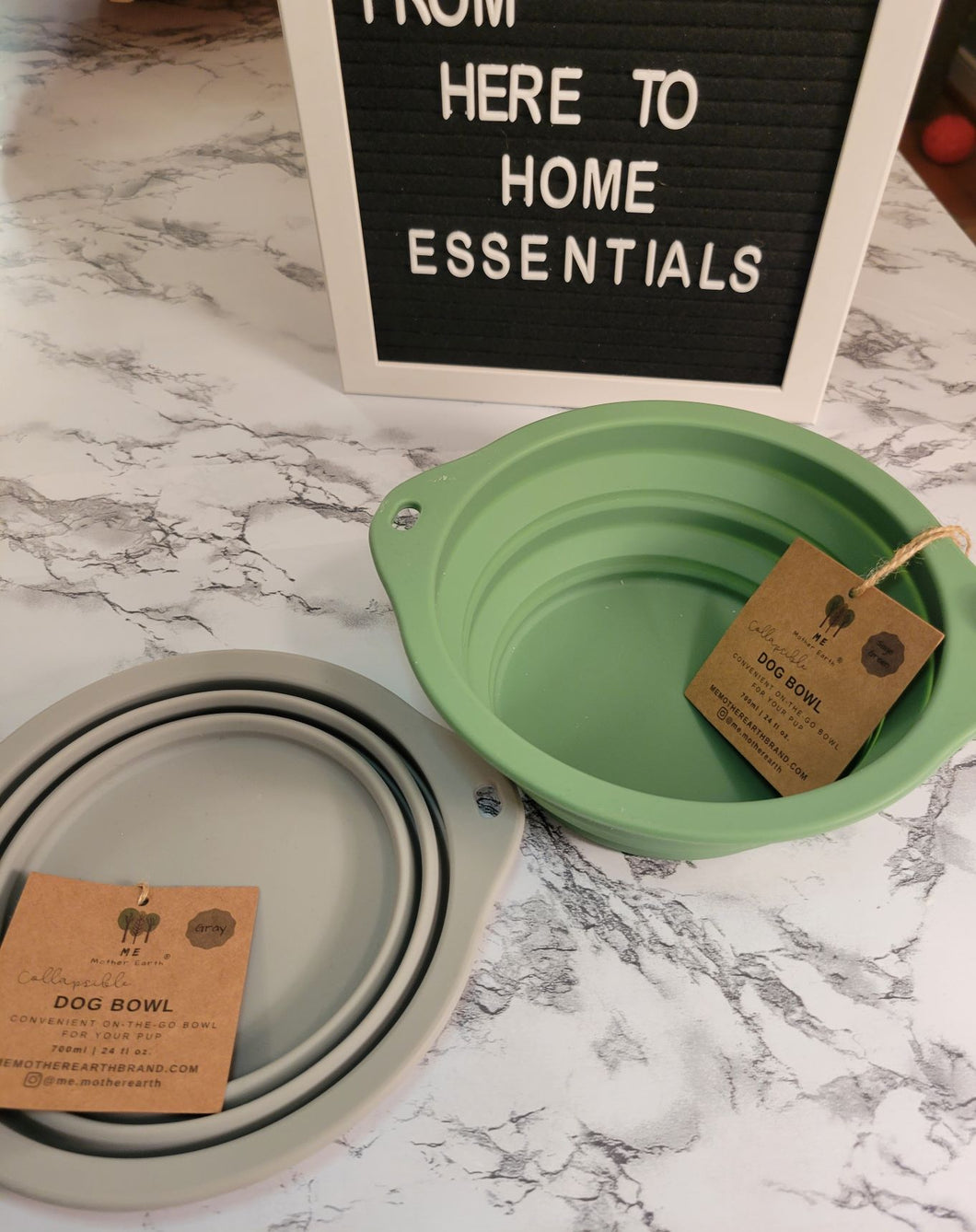 Grey and green collapsible silicone multipurpose water bowls on a table.