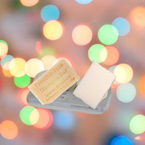 A diatomite soap dish with shampoo and conditioner bars. 