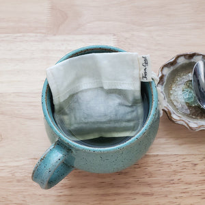 A reusable tea bag in a mug