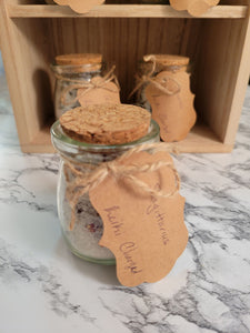 Close up of a jar of Sagittarius-inspired, reiki-charged bath salts in 4 oz glass jar with cork and paper tag.