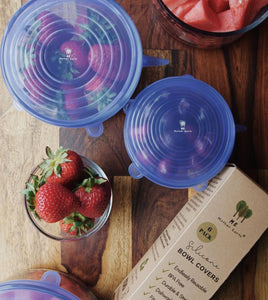 Silicone bowl covers stretched over bowls of freshly cut fruit.