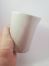 Load image into Gallery viewer, A white hand holds the jug at an angle as if about to pour from it.
